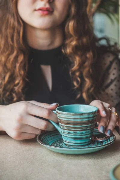 Meisje zit aan een tafel met een kop koffie — Stockfoto