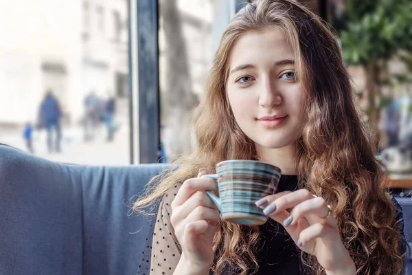 Roodharig meisje in een cafe houdt een kopje thee — Stockfoto