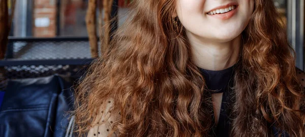 A foto mostra o ast inferior de uma jovem usando um pêssego de cabelo encaracolado vermelho longo . — Fotografia de Stock