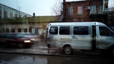 Kirli sokaklar yağmur suyuyla doldu, insanlar yağmurda toplu taşıma bekliyor ve sonra da terk ediyorlar.