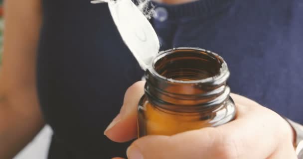 Gros plan femme ruissellement pour obtenir comprimé hors de la bouteille de médicament 