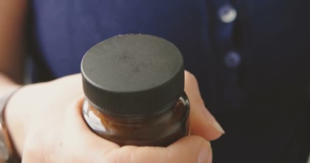 Mãos femininas abrindo garrafa pílula selada com tampa preta. Pessoa a tomar medicamentos. Alivia a dor. Rápido. — Vídeo de Stock
