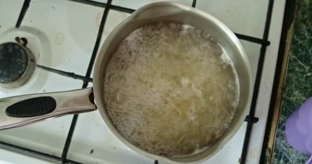 浆糊在金属锅里，水沸腾，泡沫浮在水面上. — 图库视频影像