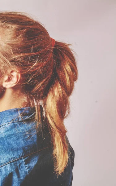 Sidobilden av en ung kvinna med blont hår invävd i en slarvig, stilren fransk fläta. — Stockfoto