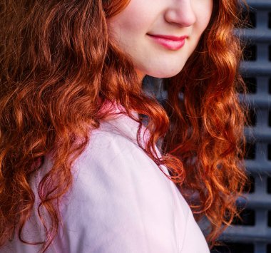 Uzun kızıl saçlı, tatlı bir kızın yüzünün alt kısmı..