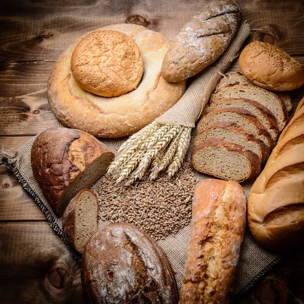 Frisches Brot, Croissants auf dem Holztisch — Stockfoto