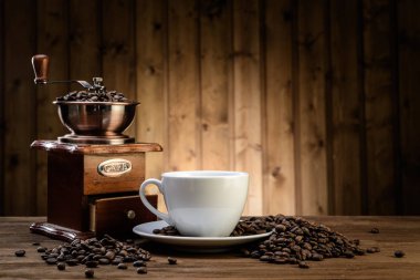 Natürmort kahve çekirdekleri ve eski Kahve değirmeni ahşap arka plan üzerinde 