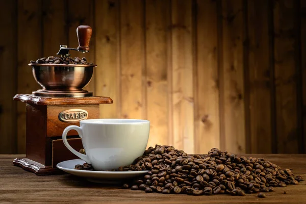 Stilleven met koffiebonen en oude koffiemolen op de houten achtergrond — Stockfoto