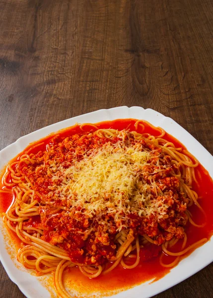 Boloňské špagety se zeleninou a mletým masem v talíř na dřevěný stůl. s prostorem kopie. pohled shora — Stock fotografie