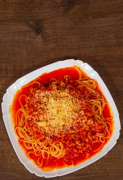 Spaghetti bolognese med grönsaker och köttfärs i en platta på träbord. med kopia utrymme. ovanifrån — Stockfoto