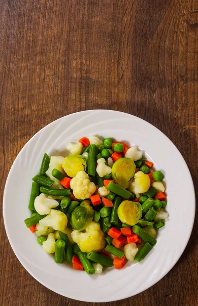 Смешанные овощи на тарелке на деревянном столе с копировальным местом. вид сверху — стоковое фото