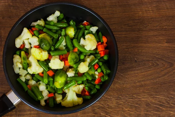 Gemengde groenten in een koekenpan. op houten tafel met kopie ruimte. — Stockfoto