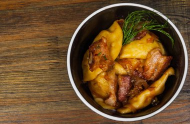 Köfte Patates ve domuz pastırması ahşap bir masa üzerinde bir kase ile