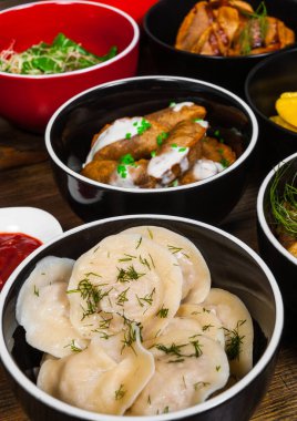 Farklı köfte ve mantı ahşap bir masa üzerinde set