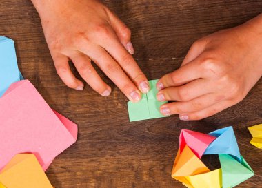Çocuk modülleri koyar. çocukların yaratıcılık kağıt, origami el sanatları, el sanatları çocuklar için yapılmış. El yapımı. ahşap masa Üstten Görünüm.