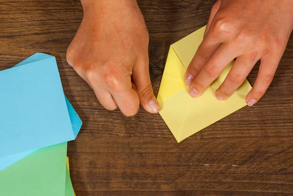 A criança coloca os módulos. criatividade infantil feita de papel, artesanato origami, artesanato para crianças. Feito à mão. na vista superior de mesa de madeira . — Fotografia de Stock