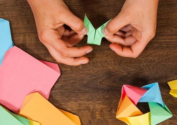 Creatività dei bambini fatta di carta, artigianato origami, artigianato per bambini. Fatto a mano. su tavolo in legno vista dall'alto . — Foto Stock