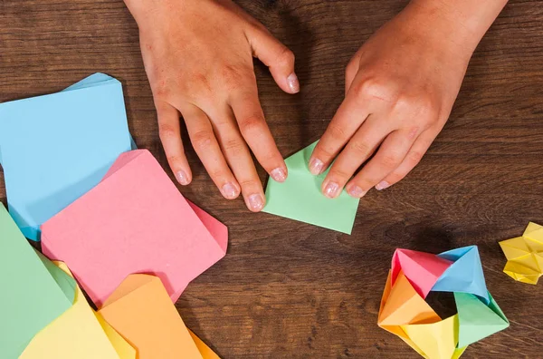 Creatività dei bambini fatta di carta, artigianato origami, artigianato per bambini. Fatto a mano. su tavolo in legno vista dall'alto . — Foto Stock