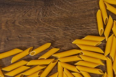 İtalyan ham rigatoni makarna penne kopya alanı ile ahşap masa üzerinde. Üstten Görünüm