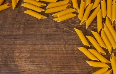 İtalyan ham rigatoni makarna penne kopya alanı ile ahşap masa üzerinde. Üstten Görünüm