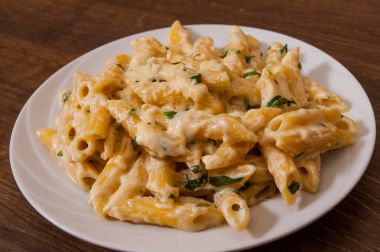 Ahşap masa üzerinde Krema soslu Penne makarna 