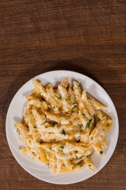 Kopya alanı ile tahta masada Krema soslu Penne makarna. Üstten Görünüm