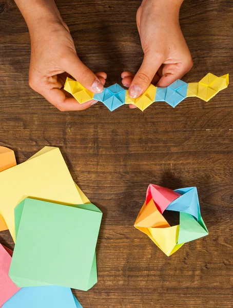 Criatividade infantil feita de papel, artesanato origami, artesanato para crianças. Feito à mão. na vista superior de mesa de madeira . — Fotografia de Stock