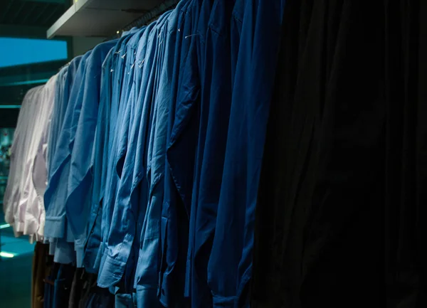 Mannen geruite overhemden in verschillende kleuren op hangers in een retail-winkel — Stockfoto