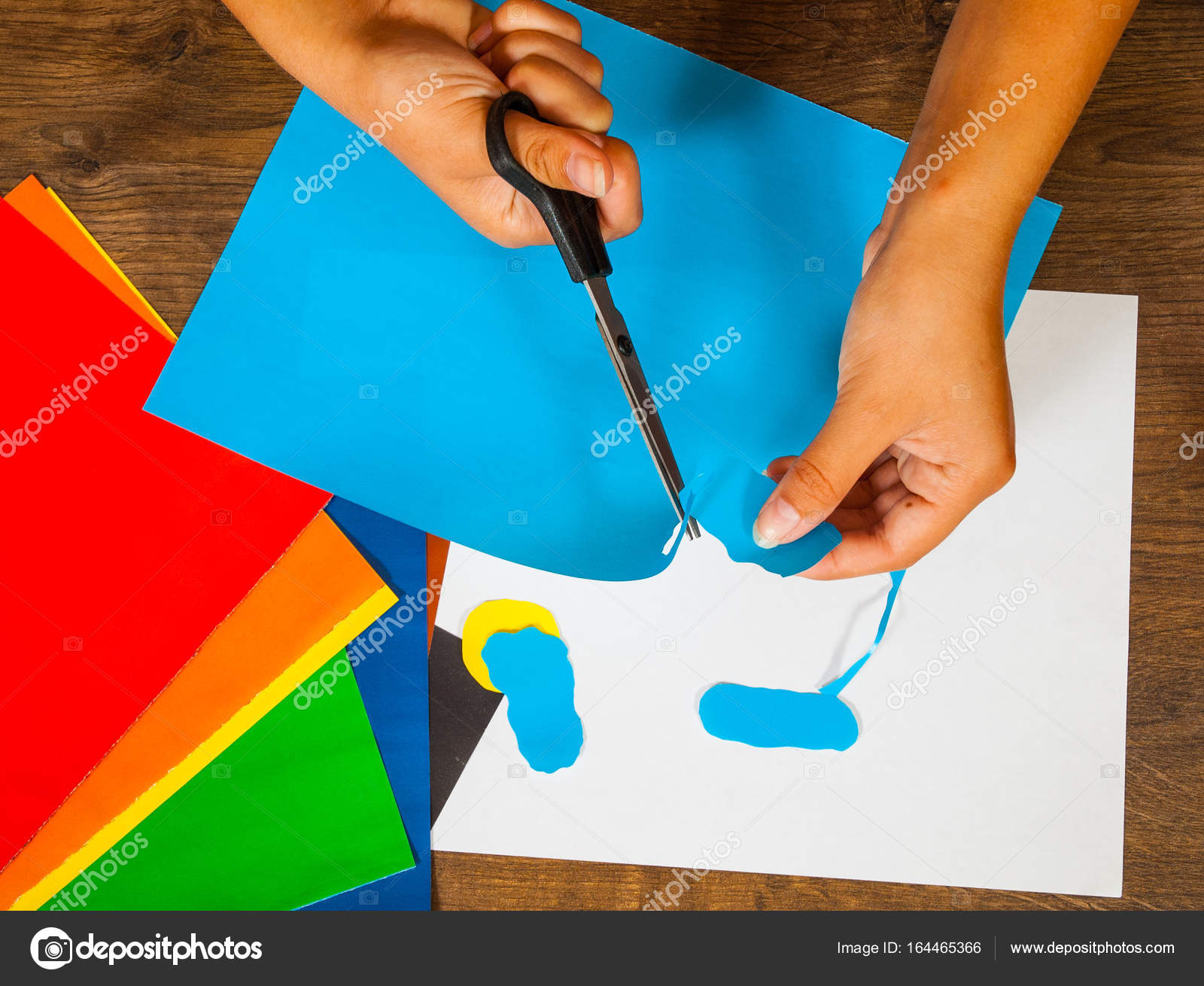 Bambino taglia carta esaurita Fogli di carta colorata Disegni dei bambini Concetto di artigianato Fatto a mano il tavolo in legno top veduta — Foto di