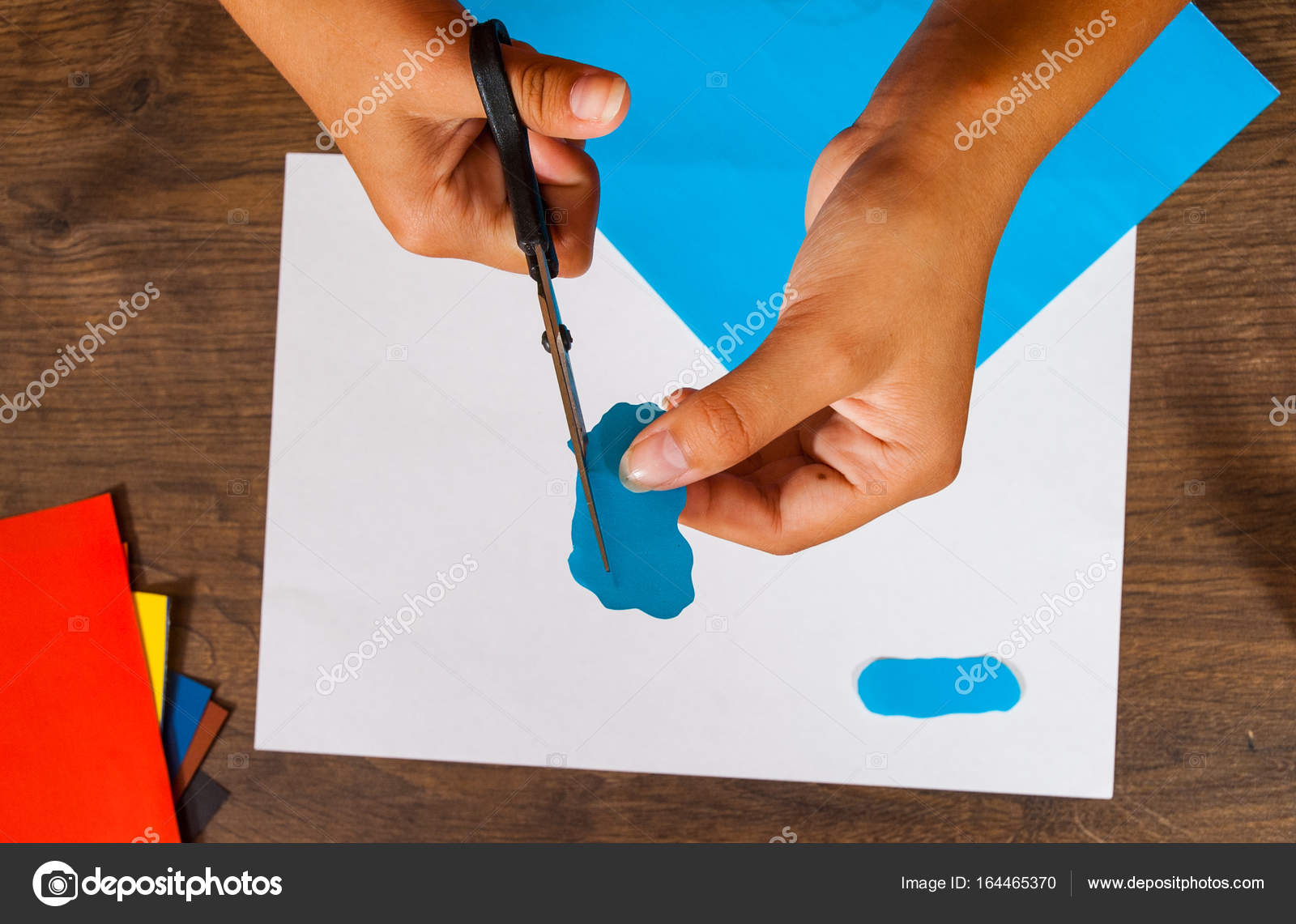 Bambino taglia carta esaurita Fogli di carta colorata Disegni dei bambini Concetto di artigianato Fatto a mano il tavolo in legno top veduta — Foto di