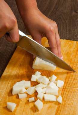 Kadın eli bir bıçakla patates mutfak ahşap tahta kesim