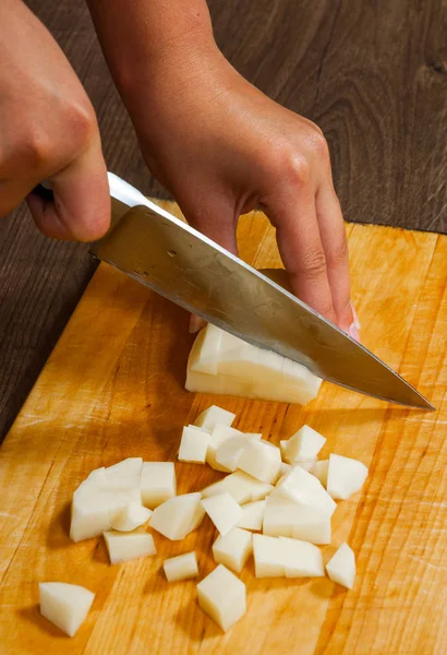Kadın eli bir bıçakla patates mutfak ahşap tahta kesim