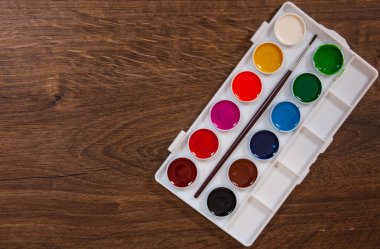 Ahşap masa plastik beyaz durumda su renkleri. kopya alanı ile. Üstten Görünüm.