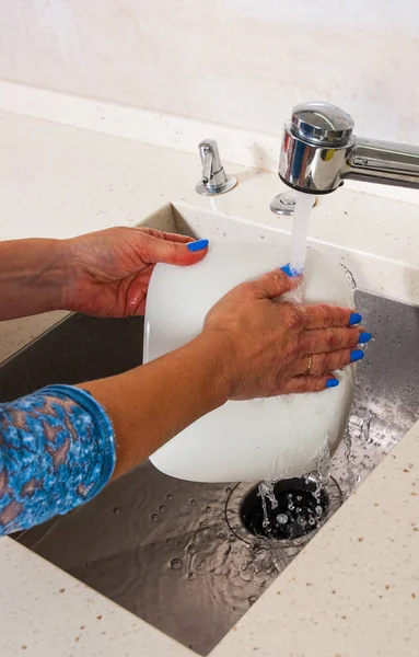 Women's hands wash dishes — Stock Photo, Image