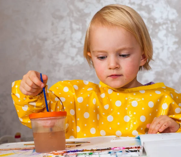 Маленька дівчинка малює акварелями — стокове фото