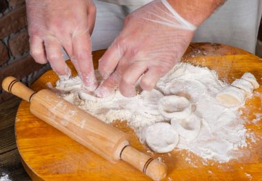 Şef ev yapımı köfte, mantı veya mantı yapma sürecinde eller