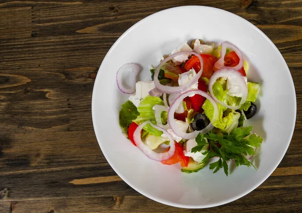 Salada vegetal com queijo, repolho, pimenta, tomate e pepino na mesa de madeira. com espaço de cópia. vista superior — Fotografia de Stock