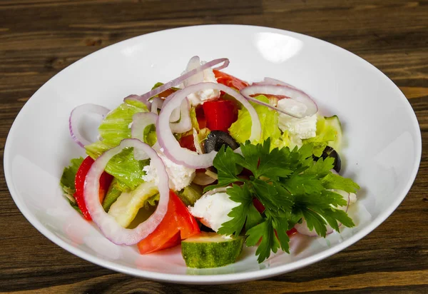 Овочевий салат з сиром, капустою, перцем, помідорами та огірком на дерев'яному столі . — стокове фото