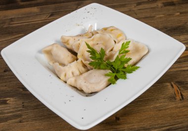 Et köfte - Rus mantı, ahşap bir zemin üzerine etli mantı. 