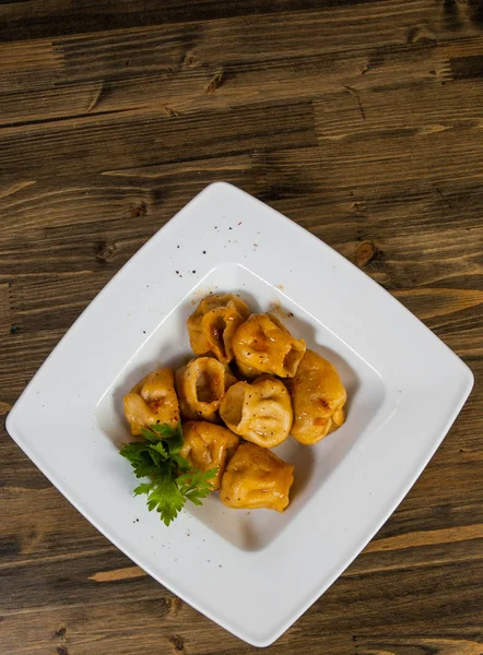 Ravioli frito com molho em um fundo de madeira. com espaço de cópia. vista superior — Fotografia de Stock