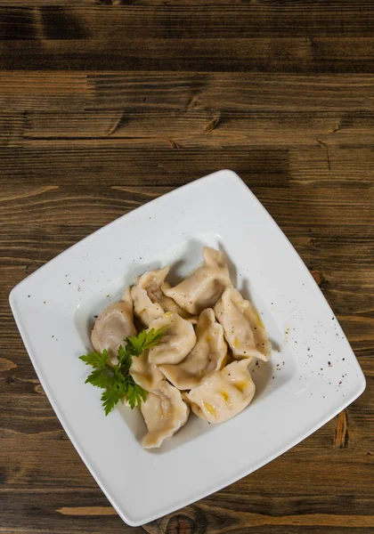 Gnocchi di carne - pelmeni russi, ravioli con carne su uno sfondo di legno. con spazio di copia. vista dall'alto — Foto Stock