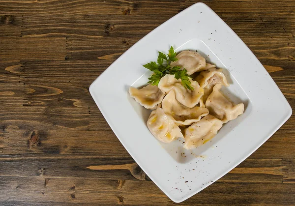 Et köfte - Rus mantı, ahşap bir zemin üzerine etli mantı. kopya alanı ile. Üstten Görünüm