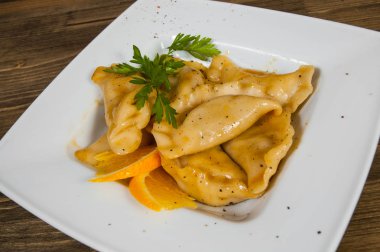 ahşap arka plan üzerinde beyaz tabakta tatlı mantı.