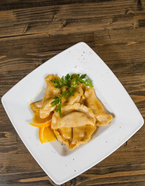 tatlı mantı ahşap arka plan üzerinde beyaz tabakta. kopya alanı ile. Üstten Görünüm