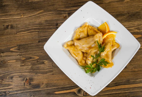 tatlı mantı ahşap arka plan üzerinde beyaz tabakta. kopya alanı ile. Üstten Görünüm