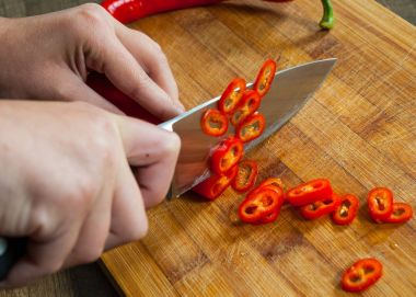 Şefler eller ahşap tahta üzerinde kesme biber biber