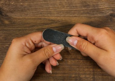 Ellerini manikür ile masaya koy. Testere belgili tanımlık tırnak şeklinde yapar. ahşap bir arka plan üzerinde. kopya alanı ile. Üstten Görünüm