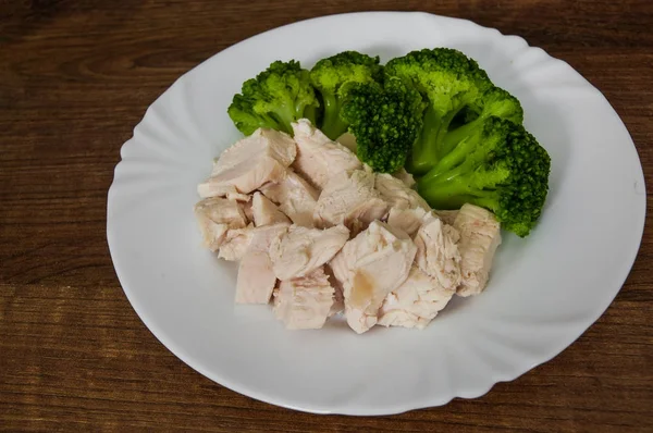 Boiled chicken fillet with broccoli on wooden background. — Stock Photo, Image