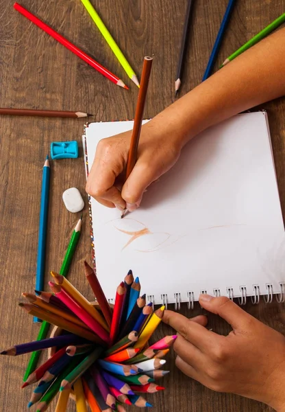 Κορίτσι σχέδιο χέρι, λευκό χαρτί και πολύχρωμα μολύβια σε ξύλινο τραπέζι — Φωτογραφία Αρχείου