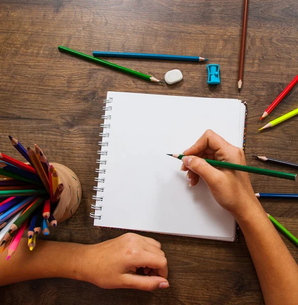 Κορίτσι σχέδιο χέρι, λευκό χαρτί και πολύχρωμα μολύβια σε ξύλινο τραπέζι — Φωτογραφία Αρχείου